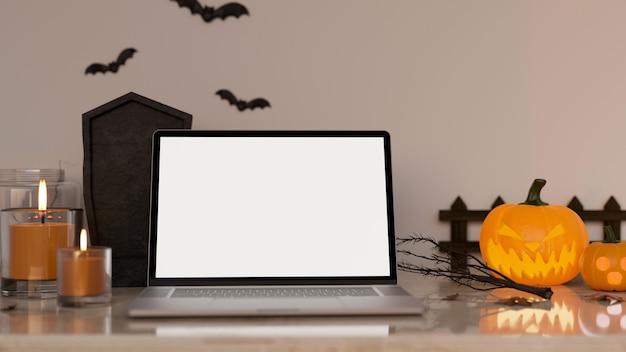 Photo workspace in halloween theme with notebook laptop white screen mockup and halloween decor