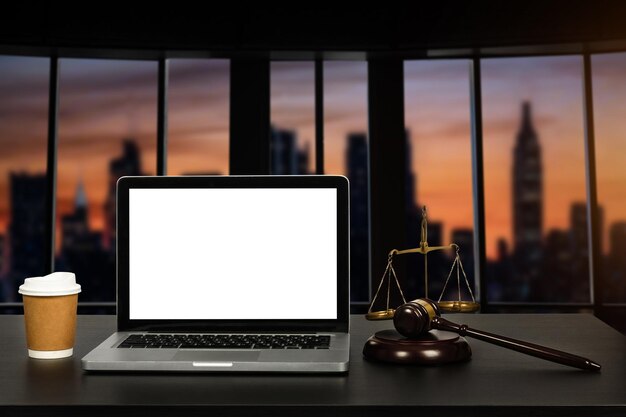 Photo workspace of lawyer with laptop blank white screen and law wooden gavel and brass scale of judge