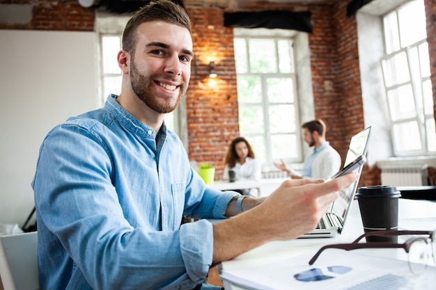 Workspace lifestyle concept. Businessman using smartphone. Handsome businessman is using a smartphone and smiling while working in office