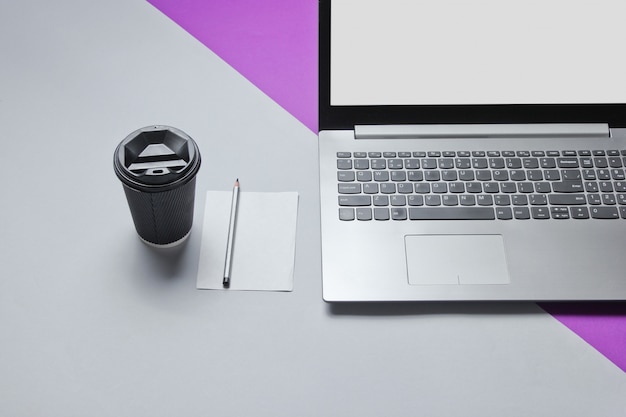 작업 공간 최소한의 개념. 노트북, 연필로 종이, 자주색 회색 테이블에 커피의 판지 컨테이너