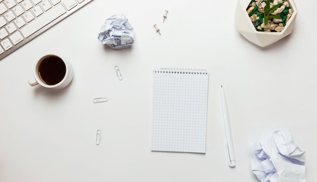 Workspace with blank clip board, keyboard, office supplies