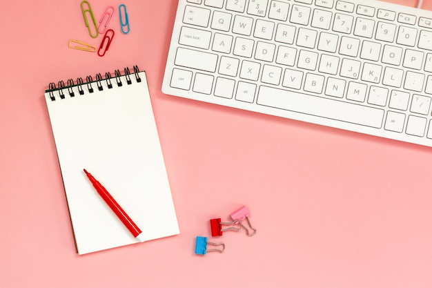 Workspace with Blank spiral notebook with keyboard on Coral