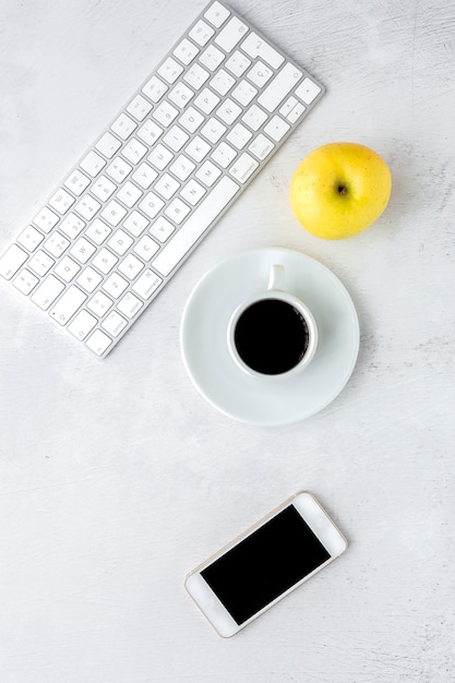 Workspace with coffee cup, apple and keyboard