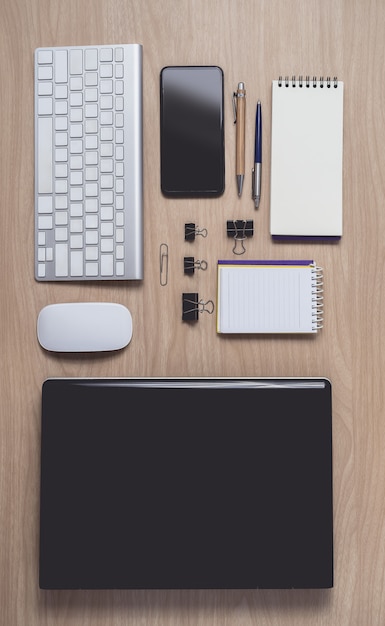 Workspace with diary or notebook and clipboard, laptop, mouse computer, keyboard, smart phone, pencil, pen