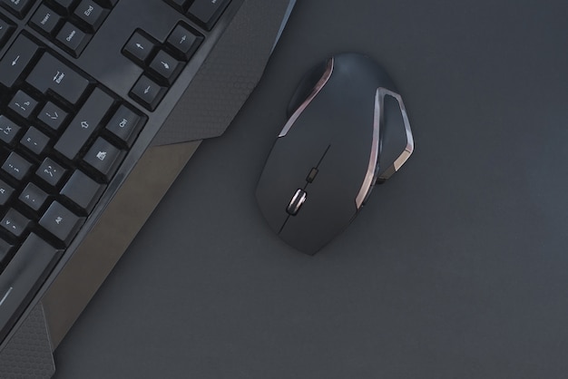 Workspace with a keyboard and mouse on a black background. Copyspace