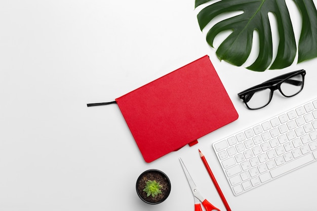 Workspace with keyboard, palm leaf and accessories. Flat lay, top view copy space