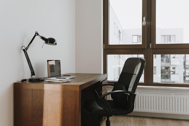 Фото Рабочее пространство с ноутбуком, компьютером, лампой, столом, стулом. концепция работы на дому. современный дизайн интерьера офиса.