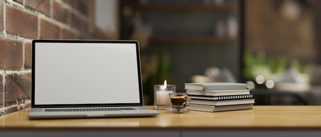 Workspace with laptop mockup and stuff on wood tabletop near the brick wall