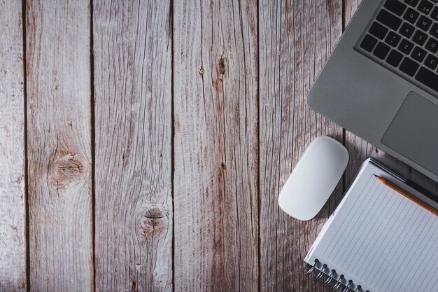 Workspace with laptop notebook and pencil on wooden background Top view Copy space Selective focus