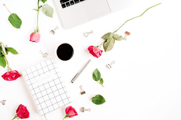 노트북, 빨간 장미 꽃, 커피 컵, 노트북 및 흰색 표면에 클립이있는 작업 공간