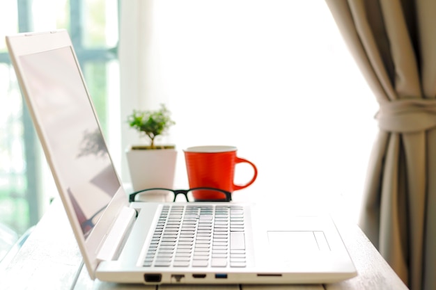 workspace with modern laptop at sunrise