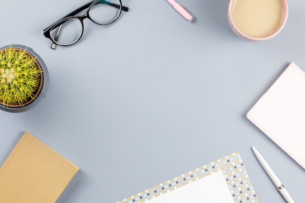 workspace with note book, eyeglasses, tea mug, diary, plant. Copy space, top view