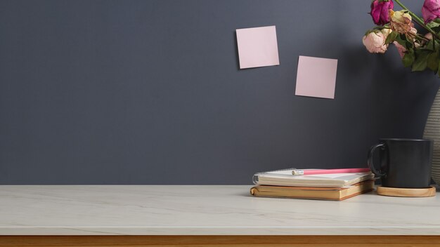 workspace with notebook, cup, flower vase and copy space in home office room