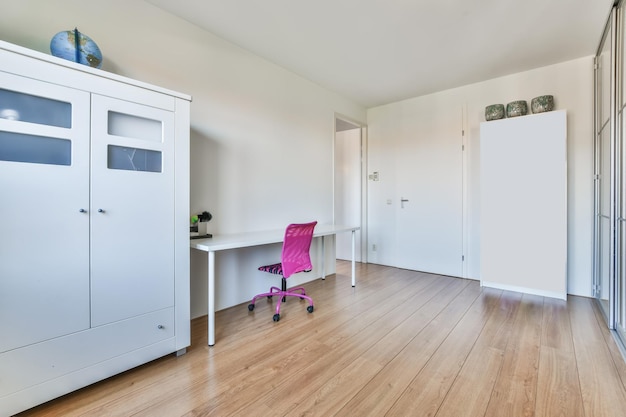 A workspace with a pink chair and a panoramic wardrobe