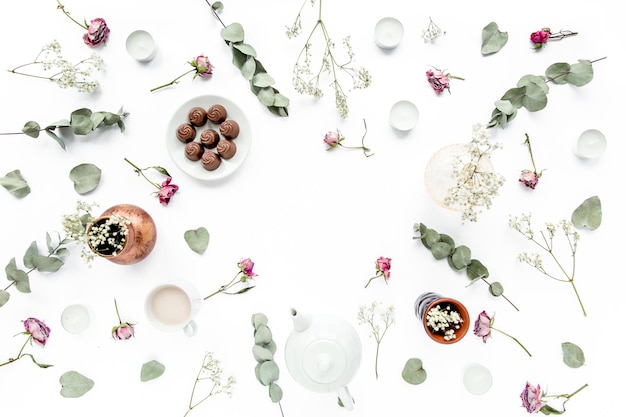 Workspace with rose buds leaves eucalyptus succulent tea cup of cocoa sweets on