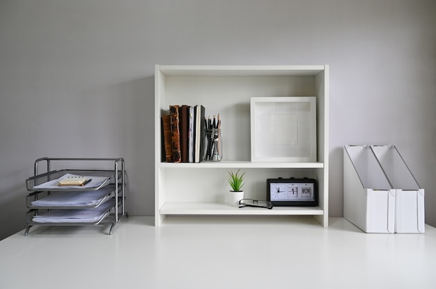Photo workspace with shelves and office supply on table.