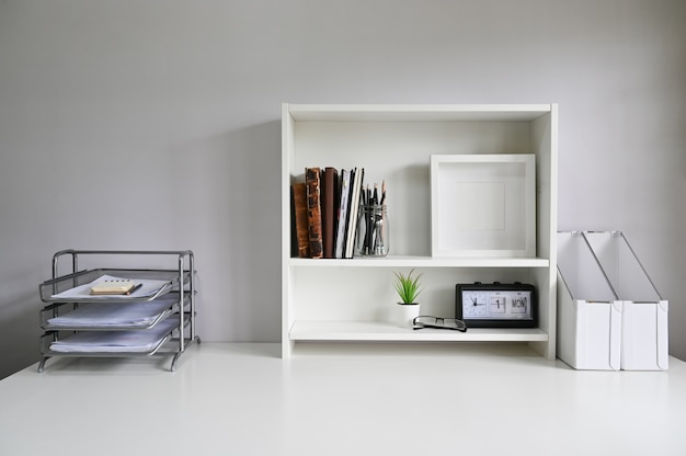 Photo workspace with shelves and office supply on table.