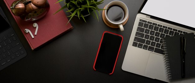 Workspace with smartphone near laptop and coffee cup