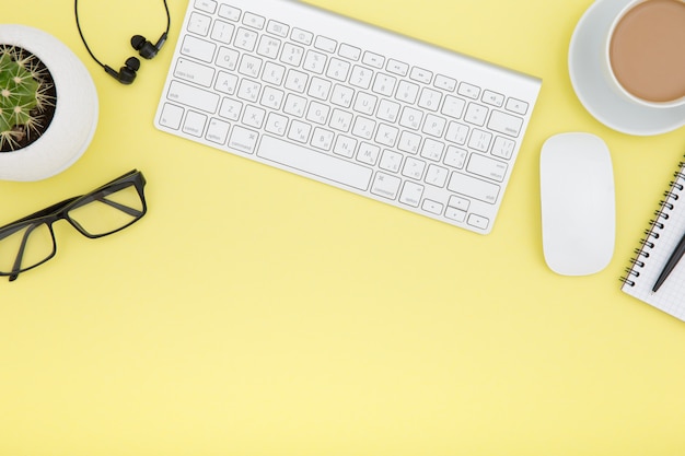 Workspace with tablet, keyboard, coffee cup and eyeglasses copy space 