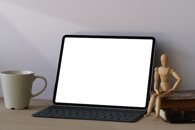 Workspace wooden desk with mockup tablet and smart keyboard 