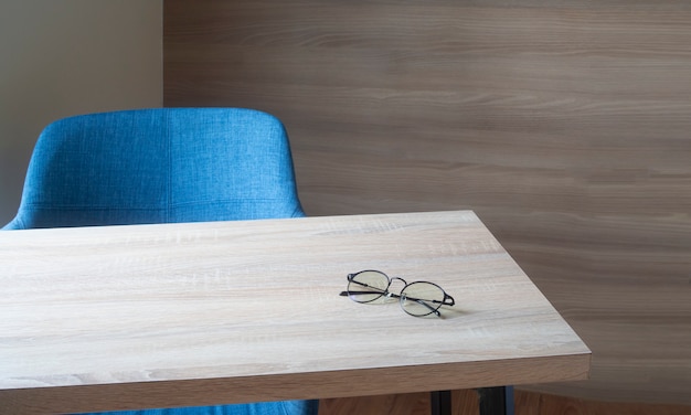 Рабочая область на деревянный стол офисный с современным синим стулом в гостиной.
