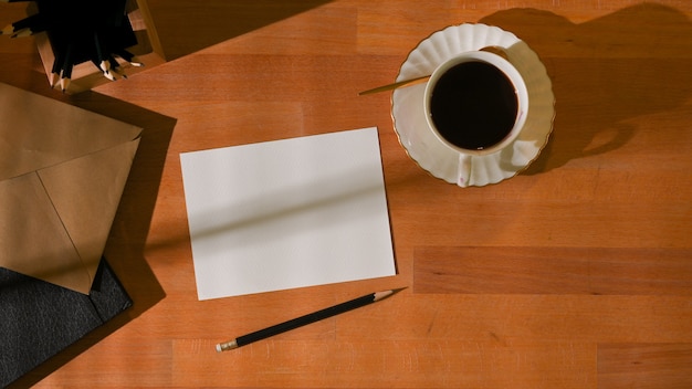 worktable with card, coffee cup and stationery in home office room