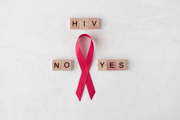 世界エイズデー。木製の文字の近くに赤いリボン。 HIV検査の概念。正または負の結果