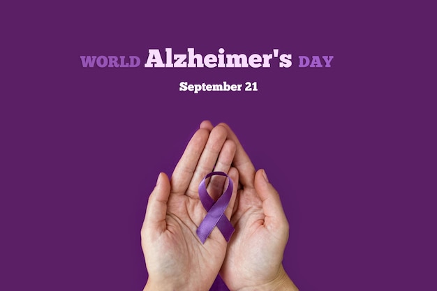 World Alzheimer's day. September 21. International Epilepsy Day. Adult hands holding purple ribbon on purple background. World Lupus Day