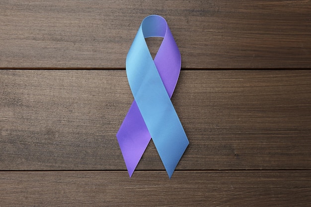 Photo world arthritis day blue and purple awareness ribbon on wooden background top view