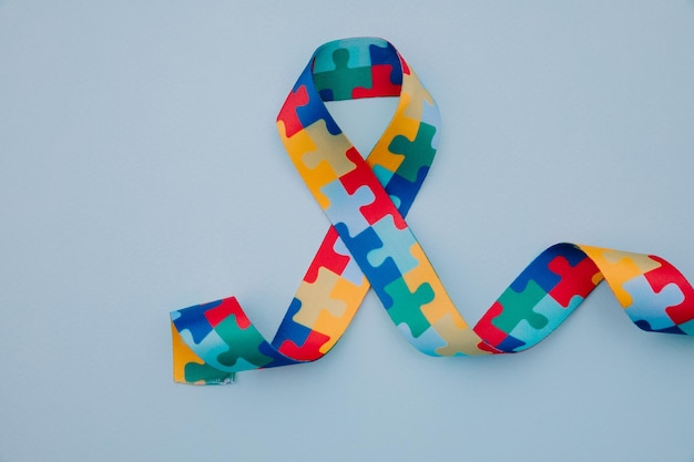 Photo world autism awareness and pride day with puzzle pattern ribbon on blue background