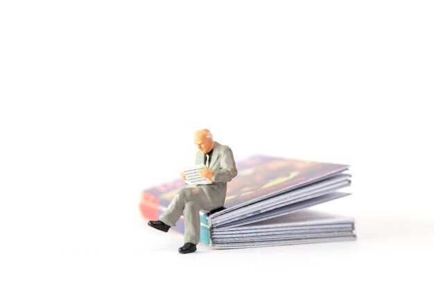 World Book Day concept Miniature people elderly guy reading a book alone