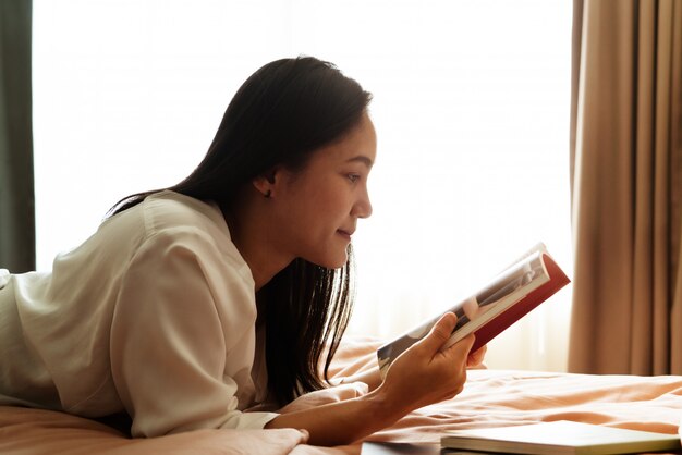 World book day, woman lay on bed reading the blank book