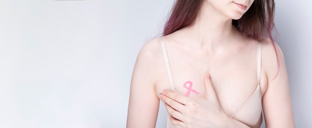 Photo world breast cancer day concept. woman in bra with pink ribbon painted on her chest. october breast cancer awareness month. copy space