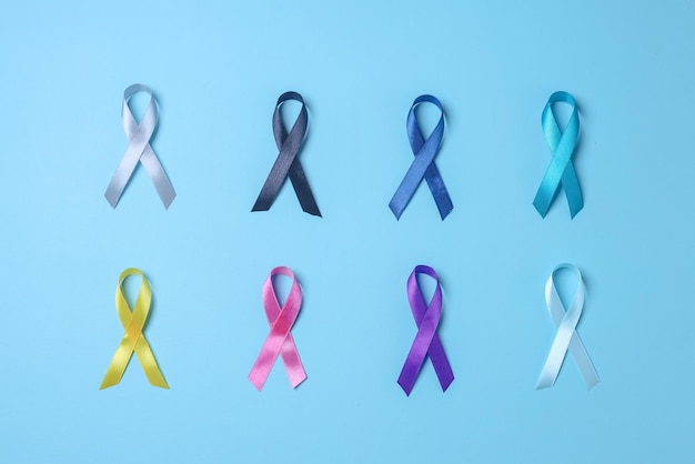 세계 암의 날. 사람들을 지원하기 위해 파란색 배경에 다채로운 인식 리본.