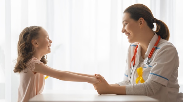 World Childhood cancer Day. Girl patient listening to a doctor in medical office.