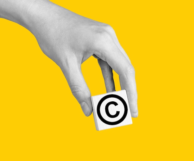 World copyright day hand with intellectual property protection patent law sign in circle on cube