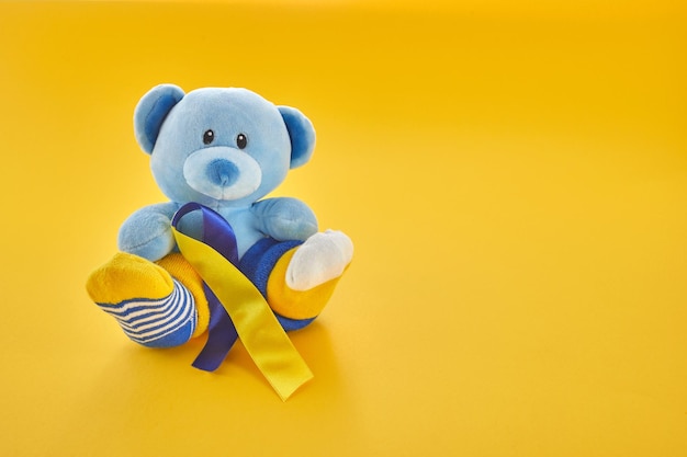 World down syndrome day backgroundteddy bear with different socks on yellow background