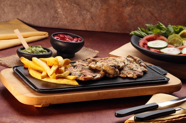 Petto di pollo alla griglia della giornata mondiale dell'alimentazione con patatine fritte in sala da pranzo cibo sano