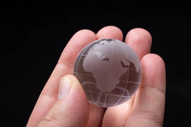 World globe crystal glass in hand Global business and economy Environmental or ecology concept