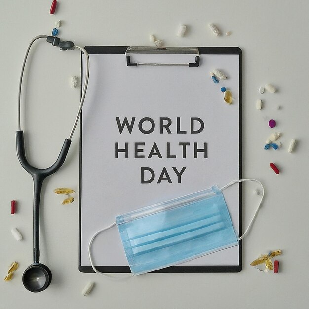 World Health Day Clipboard with stethoscopeHeart Planet Earth medical mask and pills on light