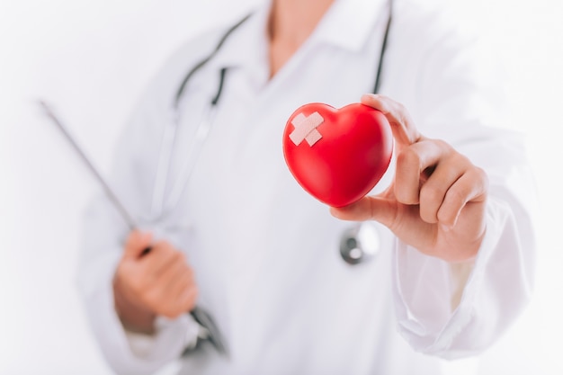 World health day, Healthcare and medical concept. Female doctor with stethoscope holding heart