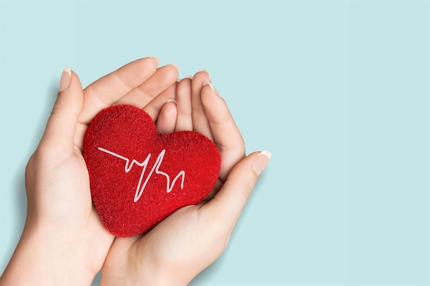 World Hypertension Day. Adult holds a red heart with a heartbeat chart,