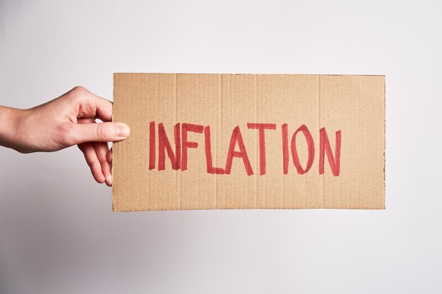 World inflation concept woman hold sheet with word inflation