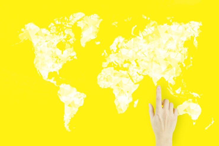 Photo world map connection in hand. global connection concept. young woman's hand finger pointing with hologram on yellow background.