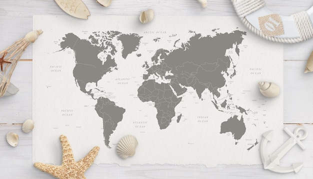 World map surrounded by shells starfish lifebelt anchor White wooden table in background Flat lay top view