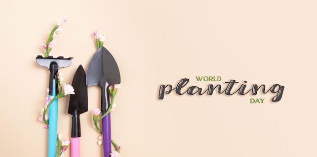 World Planting Day text with shovels and rakes for gardening flat lay Banner