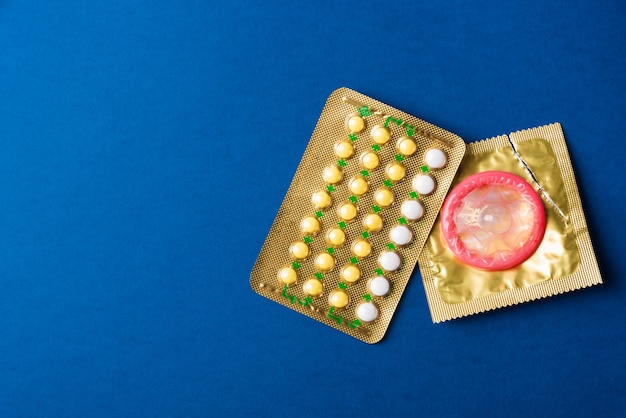 World sexual health or Aids day condom on wrapper pack and contraceptive pills blister hormonal birth control pills