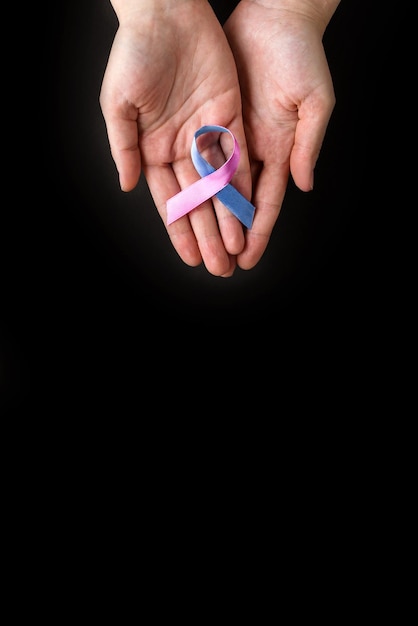 World Thyroid Day Adult hands holding Thyroid cancer awareness ribbon in Teal Pink Blue