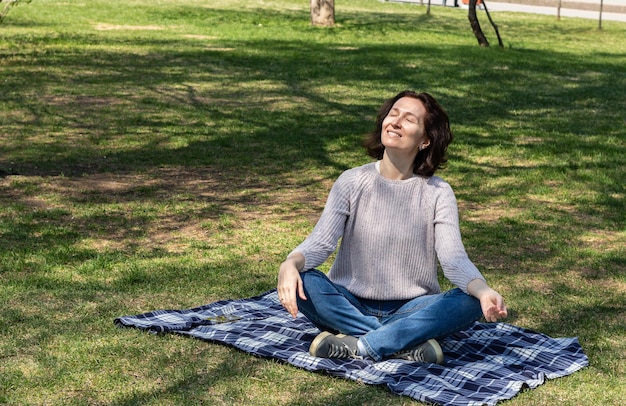 World tourism day happy adult woman resting from daily activities outdoors sitting on blanket