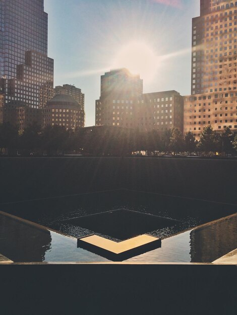 Photo world trade center memorial in city against bright sun